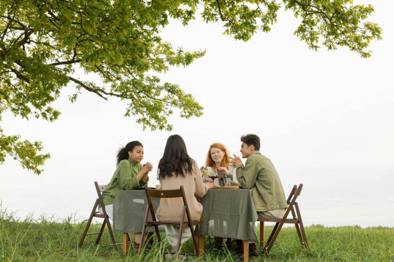 Friends enjoying a casual outdoor gathering around a table in a backyard, discussing personal stories and connections, reflecting the importance of estate planning for families in Kingwood, Texas.