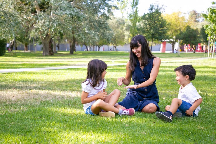Happy mother playing with two children in a park, enjoying quality family time outdoors, reflecting the importance of parental involvement in child custody matters.